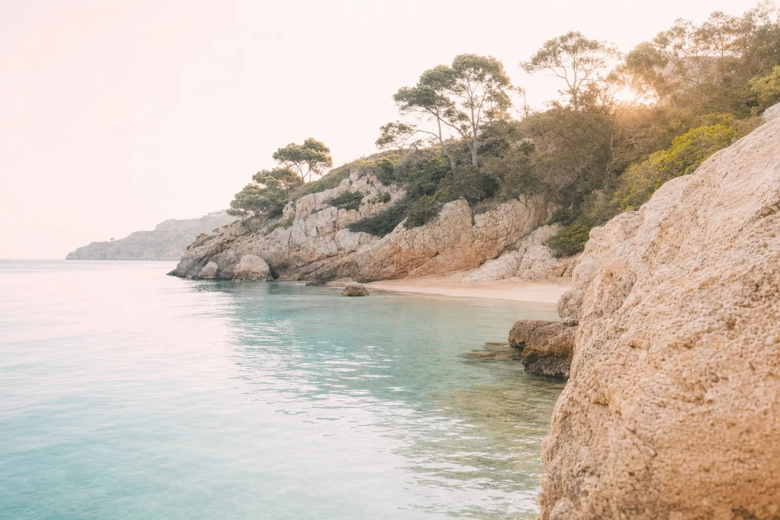 Cala serena de Mallorca amb aigua transparent i llum daurada, una invitació a la calma